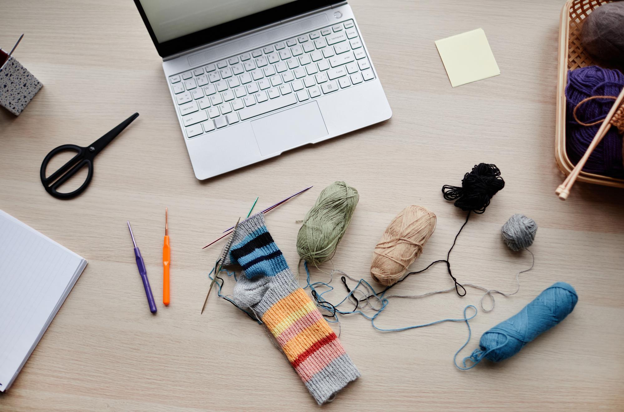 Workshop table with threads, needles and embroidered sampler